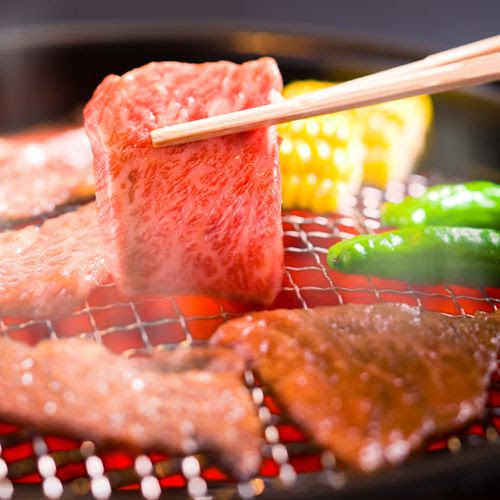 炭火グリルで焼かれるバーベキューの肉